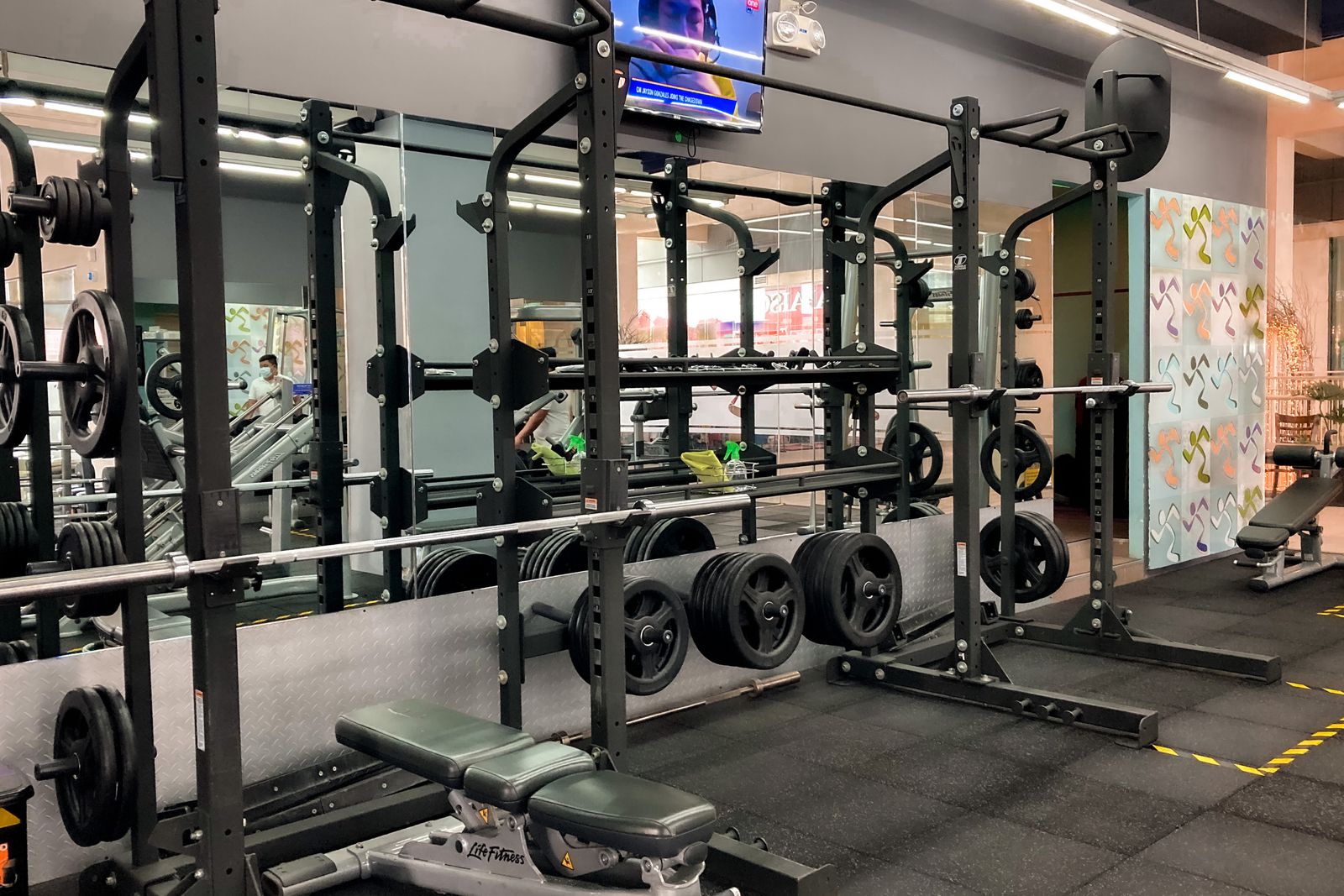 Área de musculação com pesos e estruturas de treino, em imagem provisória de referência
